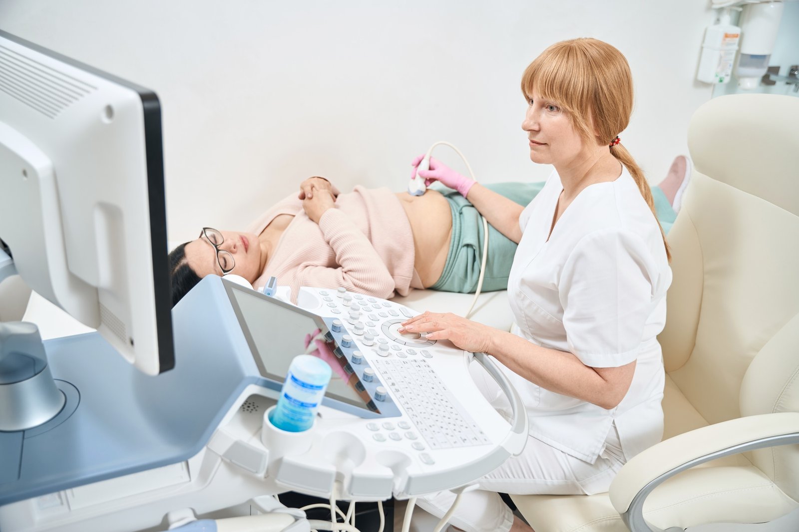Gynecologist performing extra fetal ultrasound to adult pregnant woman